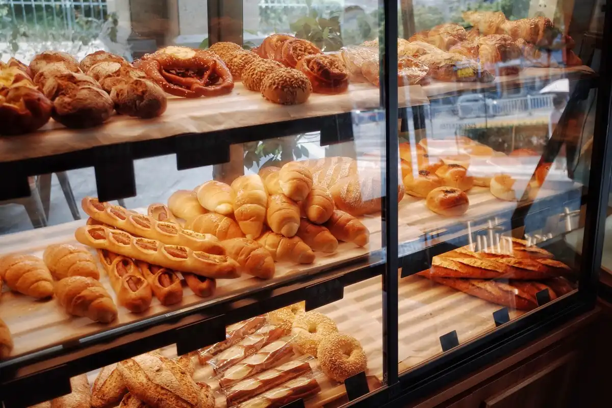 bakery staff arranging freshly baked bread and pastries