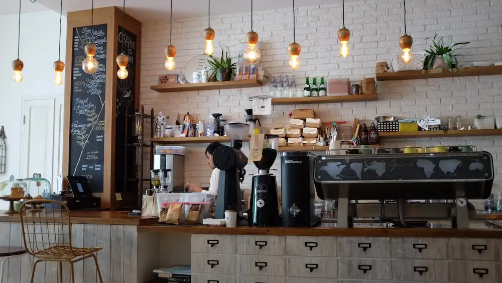 barista preparing coffee behind cafe counter