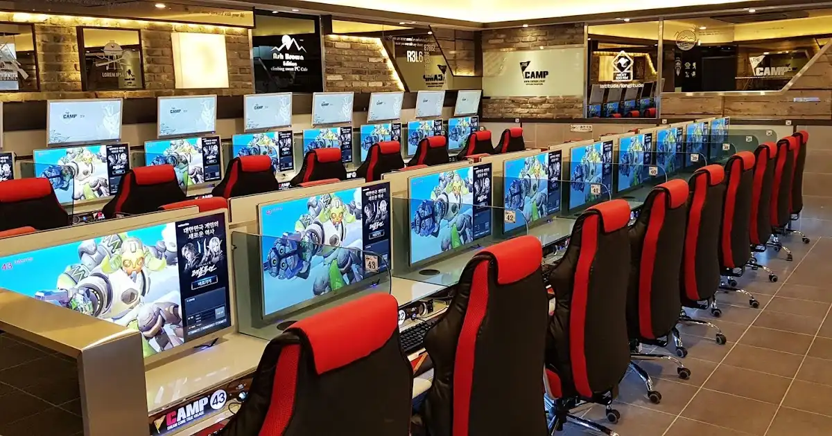 internet cafe staff assisting customers at computer stations